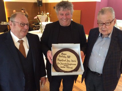 Inntöne-Festival-Veranstalter Paul Zauner gratuliert Herbert Rißel (l.) und Joe Viera (r.) mit einer Geburtstagstorte.