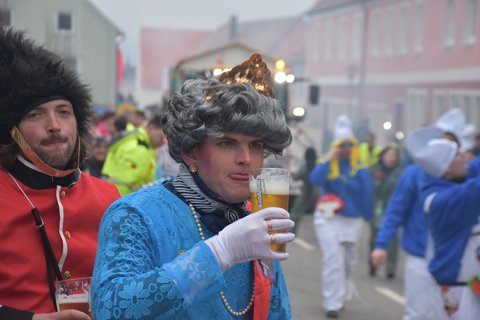 Auch zahlreiche Zuschauer kamen verkleidet. Dieser Mann gönnt sich als Queen von England ein Bier, während sein Freund als Gardegrenadier Wache hält.