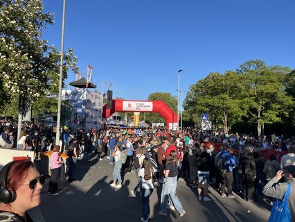 Der Zielbereich läuft voll. „Geht doch bitte weiter zu den Nudeln!“, bittet der Moderator. „Oder zum Erdinger alkoholfrei!“ Davon stehen 3500 Liter bereit. Plus 3000 Kilo Nudelsalat. Unterwegs wurden 8000 Bananen, 300 Wassermelonen und viel Wasser gereicht. 1300 Finisherinnen bekommen eine Rose. 450 Helferinnen und Helfer haben das Ereignis ermöglicht, sowie 100 Kräfte von Polizei, Maltesern und Feuerwehr. 